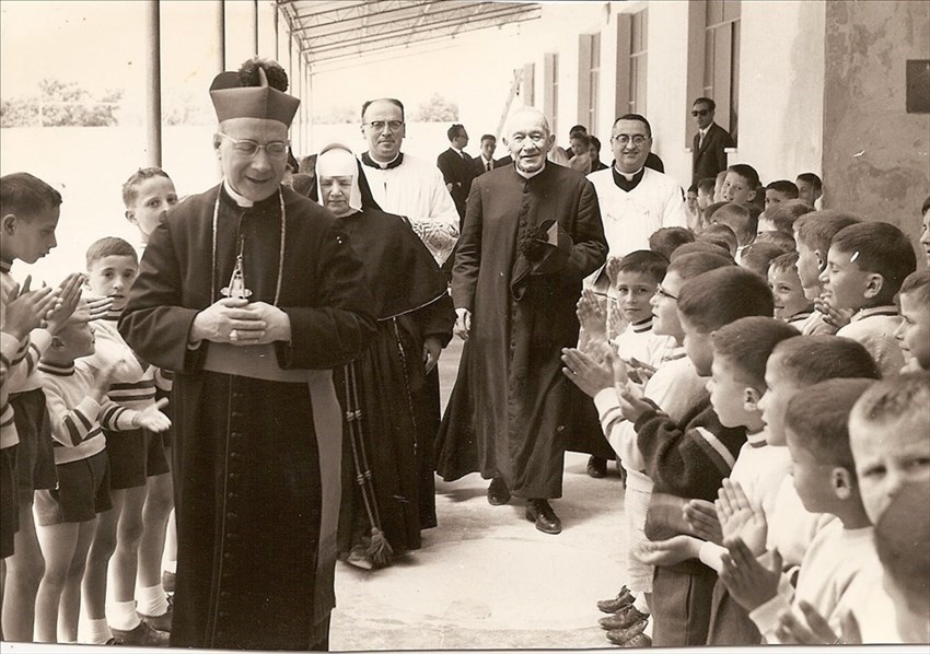 Visita monsignor Riezzo all'orfanotrofio Mater Christi. In cotta bianca il giovane sacerdote don Leonardo