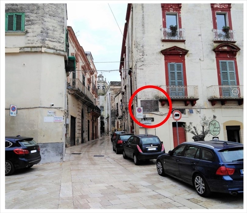 La grande targa è collocata sul muro del primo palazzo di via Vittorio Emanuele